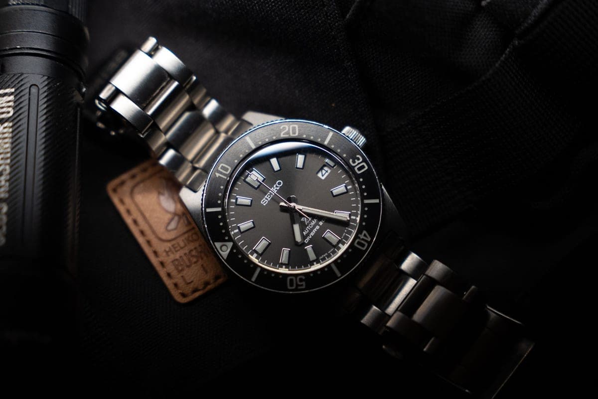 A dive watch with a rotating bezel on a dark textured surface