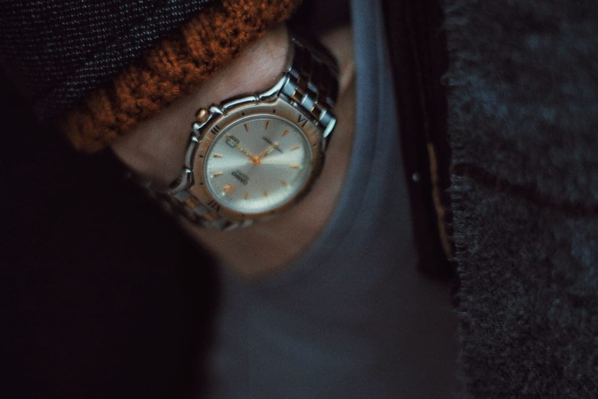 An automatic watch worn on the wrist in warm, low light